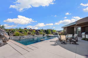 View of swimming pool with pool water feature, a patio, and area for grilling