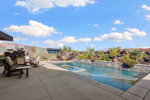 View of pool with pool water feature and a patio