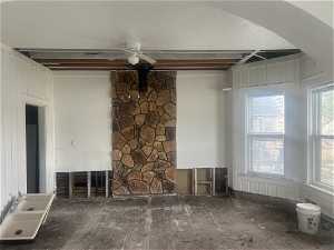 Unfurnished living room with ceiling fan and a textured ceiling