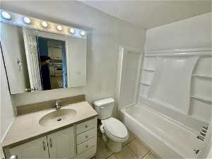 Full bathroom featuring toilet, bathtub / shower combination, tile flooring, and vanity