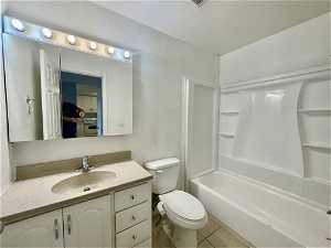 Full bathroom with toilet, tile flooring, bathtub / shower combination, and large vanity