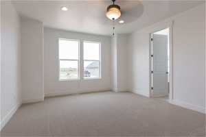 Spare room with ceiling fan and light carpet
