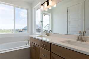 Bathroom featuring double sink vanity and a bath
