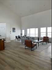 Living room featuring a high ceiling and light hardwood / wood-style flooring