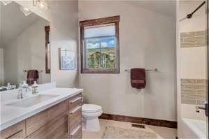 Bathroom with toilet, tile flooring, vaulted ceiling, and vanity