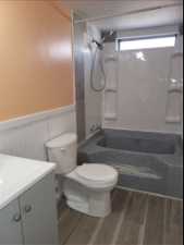 Full bathroom with toilet,  shower combination, vanity, and wood-type flooring