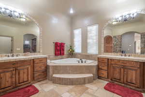 Master Bathroom with tiled bath, tile floors, a chandelier, and double vanity