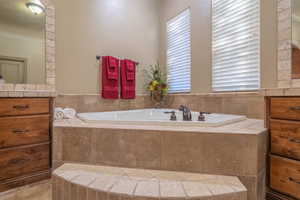 Bathroom featuring a relaxing jetted bathtub and vanity