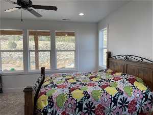Carpeted Master bedroom with multiple windows and ceiling fan
