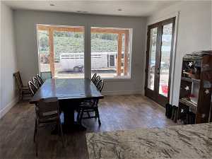 Dining area with dark hardwood / wood-style floors, french doors, and a wealth of natural light