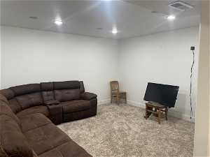 View of carpeted Media room in basement with surround sound.