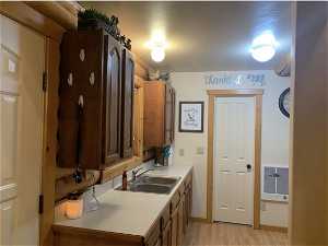 Kitchen featuring sink and light hardwood / wood-style flooring with stove top and door to bathroom