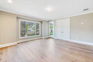 Interior space featuring ornamental molding and light wood-type flooring