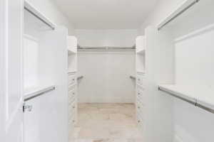 Walk in closet with light tile flooring