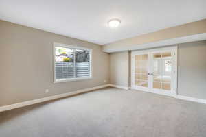 Spare room with carpet floors and french doors