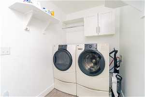 Laundry room featuring washer and dryer, light LVP flooring, cabinets, hanging rod, shelving, and hookup for a washing machine