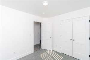 Unfurnished bedroom with a closet and light carpet