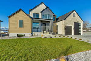 Contemporary home featuring a garage and a front lawn