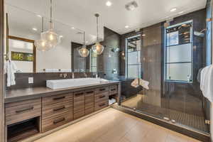 Bathroom featuring a shower with door, vanity, and tile patterned flooring