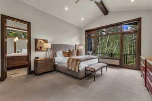 Bedroom with light carpet, access to outside, connected bathroom, and beam ceiling