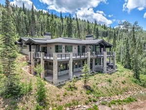 Back of property featuring a wooden deck and a patio