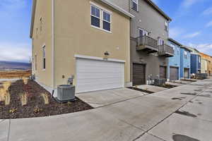 Exterior space with a garage, a balcony, and central air condition unit