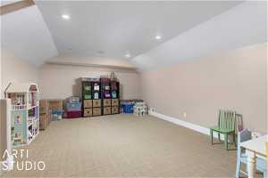 Game room over garage with vaulted ceiling and light carpet