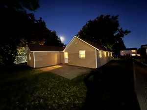Property exterior at night featuring a yard and a patio area