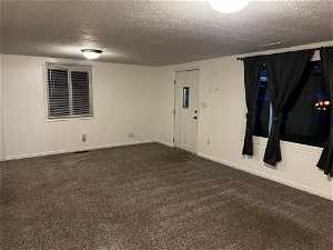 Unfurnished room featuring carpet floors and a textured ceiling