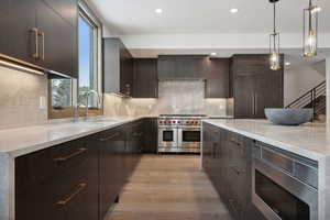 Walnut cabinets with Taj Mahal Quartzite waterfall slabs, Wolf appliances