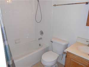 Full bathroom featuring shower / bath combination with curtain, toilet, and vanity