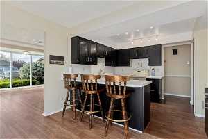 Kitchen featuring dark hardwood / wood-style floors, range, a textured ceiling, and kitchen peninsula