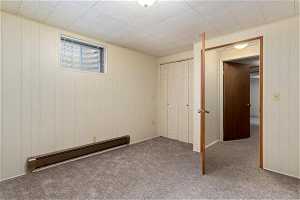Interior space featuring a baseboard heating unit and carpet floors
