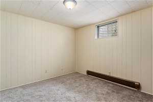 Carpeted empty room with baseboard heating and a paneled ceiling