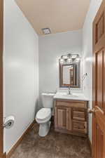 Bathroom featuring toilet, tile flooring, and vanity