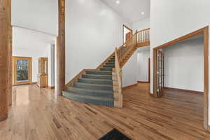 Staircase with light hardwood / wood-style flooring and a high ceiling