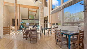 Dining room with light wood-type flooring, high vaulted ceiling, and beam ceiling