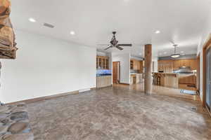 Unfurnished living room with light tile floors and ceiling fan