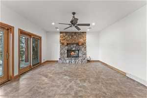 Unfurnished living room with ceiling fan, a fireplace, and light tile floors
