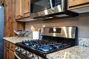 Kitchen featuring stainless steel appliances and light stone countertops