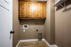 Laundry room with hookup for a gas or electric dryer, cabinets, tile flooring, and hookup for a washing machine
