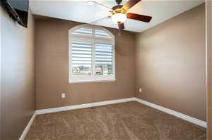 Accessory bedroom featuring ceiling fan and carpet