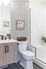 Bathroom featuring toilet, vanity with extensive cabinet space, and tile flooring