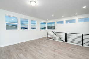 Spare room with light wood-type flooring and plenty of natural light