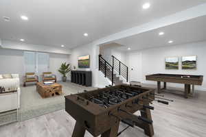 Playroom with light wood-type flooring and billiards