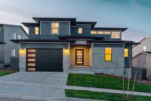 View of front of house with a yard and a garage