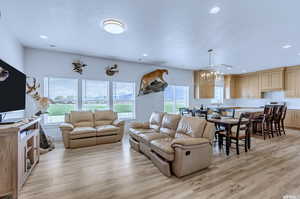 Living room with sink, light hardwood / wood-style floors, and a chandelier