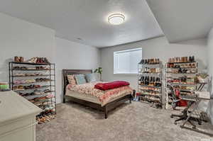 Bedroom featuring a textured ceiling and light carpet