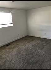 Carpeted, spacious bedroom.