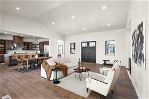 Living room featuring dark hardwood / wood-style floors, sink, and vaulted ceiling